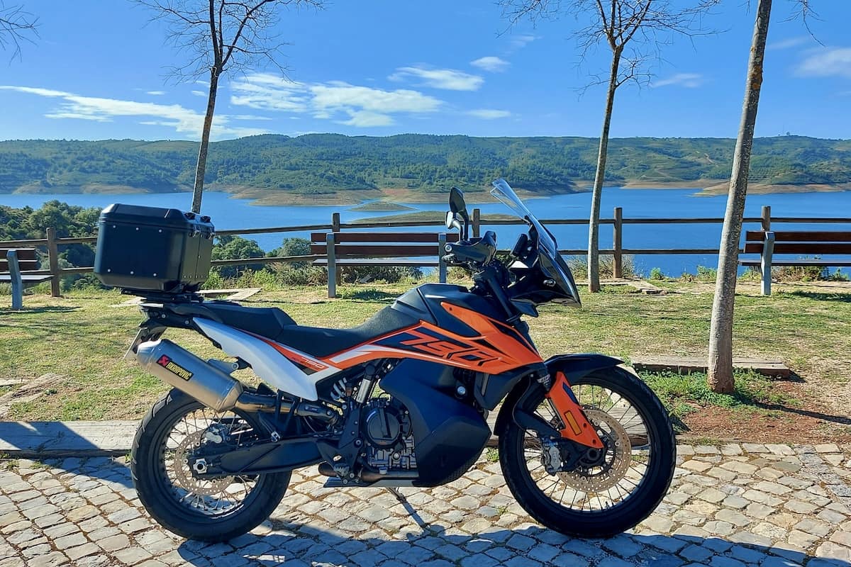 KTM 790 Adventure parada no miradouro da Barragem de Odeleite, Algarve. Moto de aventura laranja e preta com escape Akrapovic e top case. Rota de motociclismo no sotavento algarvio.